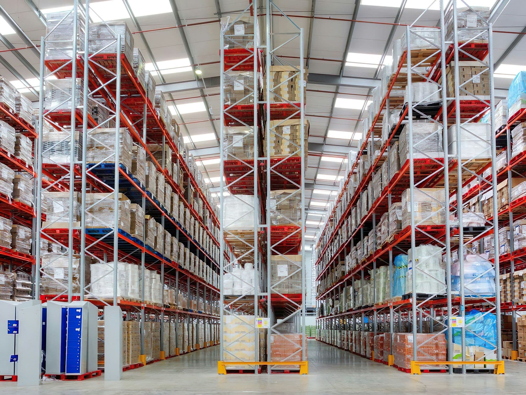 Long warehouse aisle of pallet racking stacked with cased stock